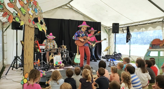 Concert Camion Vert sous chapiteau devant des enfants assis